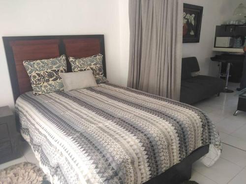 a bedroom with a large bed and a couch at Casa bonita a dos cuadras del mar in Playa del Carmen