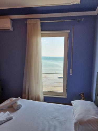 1 Schlafzimmer mit einem Fenster mit Blick auf den Strand in der Unterkunft Seaview Luxury Apartment in Durrës