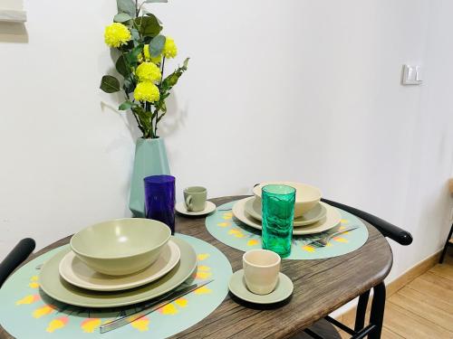 un tavolo con piatti e tazze e un vaso con fiori di Casa das Férias a Lisbona