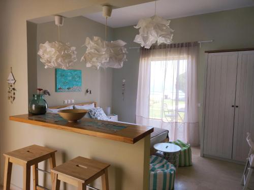カボスにあるThalassa Apartments & Studiosのキッチン(カウンター、スツール2つ、シンク付)