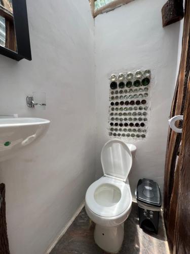 a white bathroom with a toilet and a sink at The Valley Tayrona hostel- A social jungle hostel in El Zaino