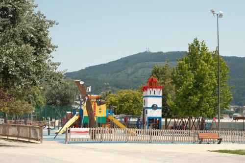 une aire de jeux avec un toboggan et un phare dans un parc dans l'établissement Precioso piso en el centro de Moaña, à Moaña