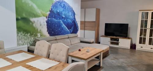 a living room with a couch and a table and a tv at Apartament FIORE BLU ( vedere la mare si lac) in Năvodari