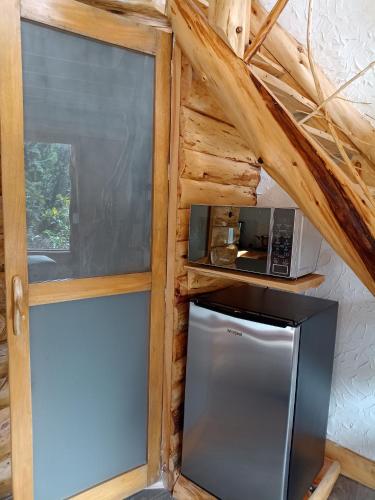 a kitchen with a stainless steel refrigerator and a microwave at Cabaña en la calera el Pinar in La Calera