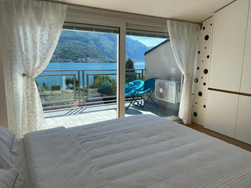 Oliveto LarioにあるLe Terrazze sul Lago di Comoのベッドルーム1室(ベッド1台付)、景色を望むバルコニーが備わります。