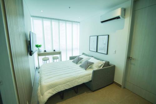 a bedroom with a bed with pillows on it at Suite de lujo Distrito 90 in Barranquilla