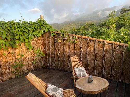 a patio with two chairs and a table with a view at The Valley Tayrona hostel- A social jungle hostel in El Zaino