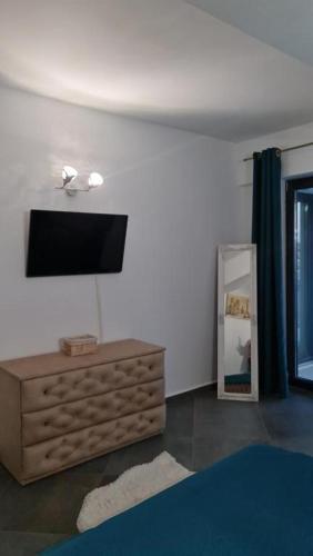 a living room with a television on a wall at Apartament FIORE BLU ( vedere la mare si lac) in Năvodari