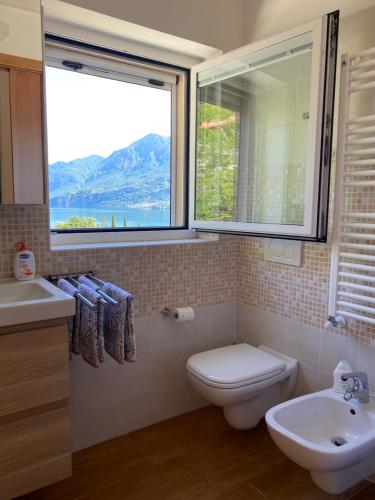 baño con lavabo y aseo y ventana en Le Terrazze sul Lago di Como, en Oliveto Lario