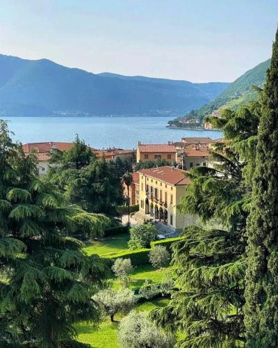 a view of a town with a lake in the background at Villa Riva Lago - Apartment with garden and parking in Tavernola Bergamasca
