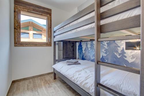 une chambre avec deux lits superposés et une fenêtre dans l'établissement Carlina 203, à Morzine