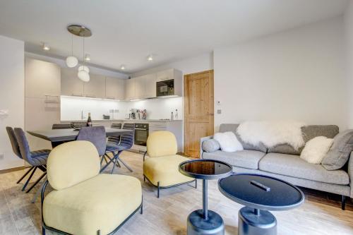 un salon avec un canapé, des chaises et une table dans l'établissement Carlina 203, à Morzine