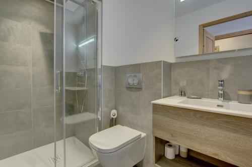 une salle de bain avec une douche, des toilettes et un lavabo dans l'établissement Carlina 203, à Morzine