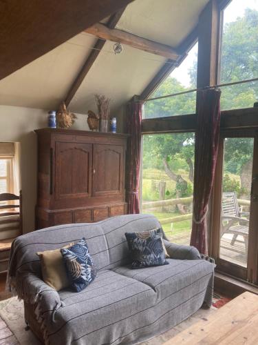 a living room with a couch with pillows on it at Little Pentre Barn with cosy logburner in Wrexham