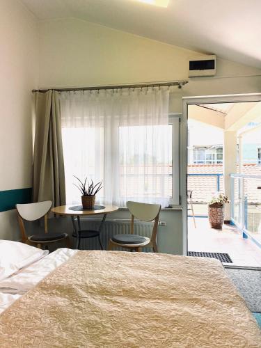 a bedroom with a bed and a table and chairs at Yacht Club Residence Sopot in Sopot