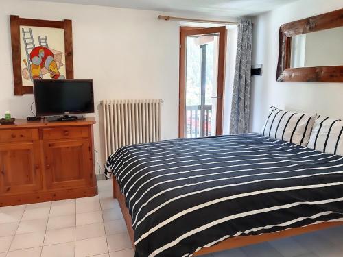 a bedroom with a bed and a tv on a dresser at Casa Lo Tzé in Valtournenche