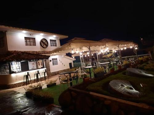 a house with an outdoor patio at night at Hotel & Suites en Cuenca, Venue Batán in Cuenca
