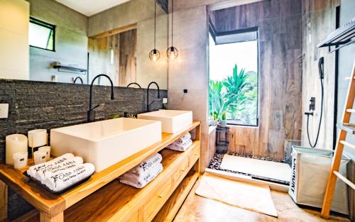 a bathroom with two sinks and a large mirror at Casa Anna Santa Teresa in Santa Teresa Beach