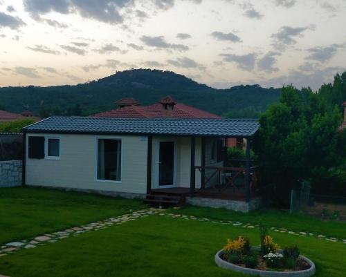 a small white house with a mountain in the background at Naturalayos I y Naturalayos II - casas para parejas - jacuzzi in Pelayos de la Presa