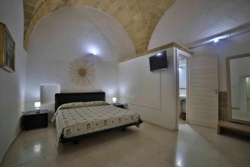 a bedroom with a bed and a television in a room at Palazzo Zacheo in Gallipoli