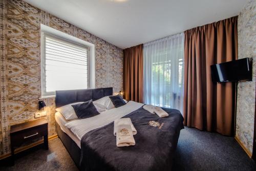 a bedroom with a large bed and a window at Srebrny Bucznik Wellness & Restaurant in Istebna
