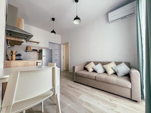 ein Wohnzimmer mit einem Sofa und einer Küche in der Unterkunft Apartments Happy in Sukošan