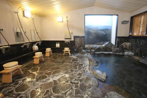 a bathroom with a pool of water with toilets at Shitanda in Takayama