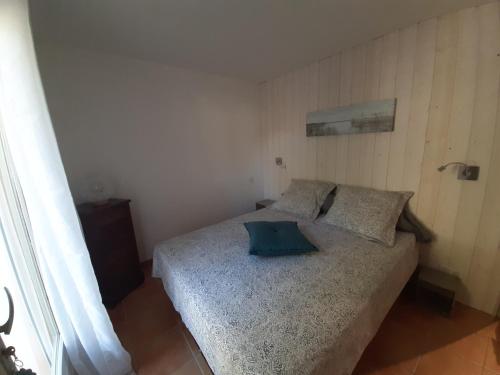 ein Schlafzimmer mit einem Bett mit einem blauen Kissen darauf in der Unterkunft Le Méditerranéo in Saint-Aygulf