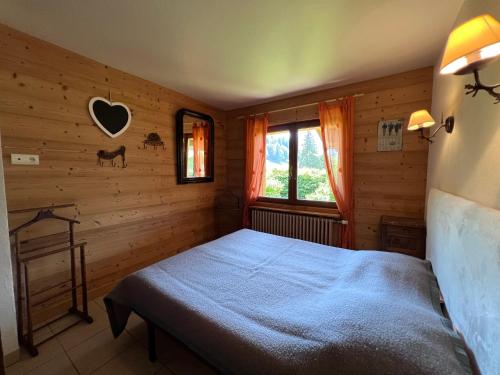 a bedroom with a bed in a wooden room at Petit Lutin - Chalet sur les pistes in La Clusaz