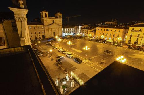 a view of a street at night with lights at Piazza del Mercato in LʼAquila