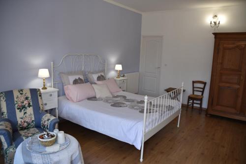 a bedroom with a white bed with pink pillows at La Little School Chambres d'Hôtes à Arçay in Arçay