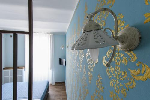a bedroom with a lamp on a blue wall at Piazza del Mercato in LʼAquila