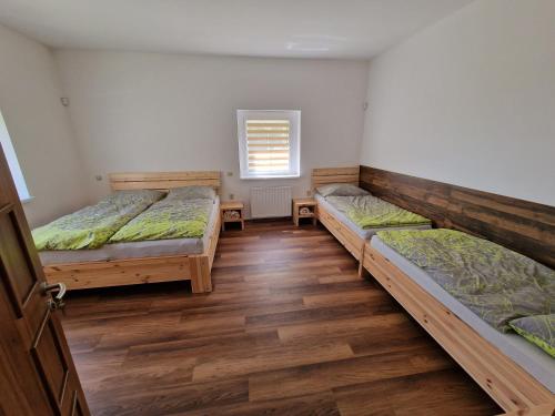 a room with three beds and a window at Hájenka in Třebívlice