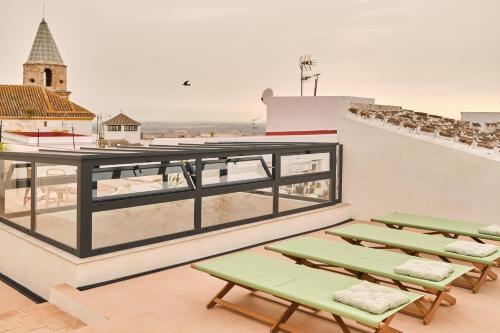 a group of green benches on the roof of a building at VICTORIA - by Ático73 in Medina Sidonia