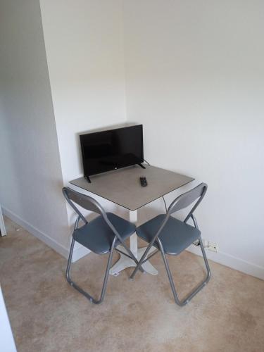 a table with two chairs and a computer monitor at Studio - Marina 4 - 13 allée des Pinons - 4-1 in Saint-Jean-de-Monts