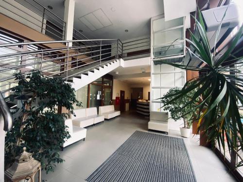 an office lobby with a staircase and plants at Yacht Club Residence Sopot in Sopot