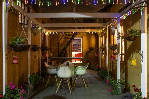 a patio with a table and chairs and lights at The Tuscan Garden in Newcastle