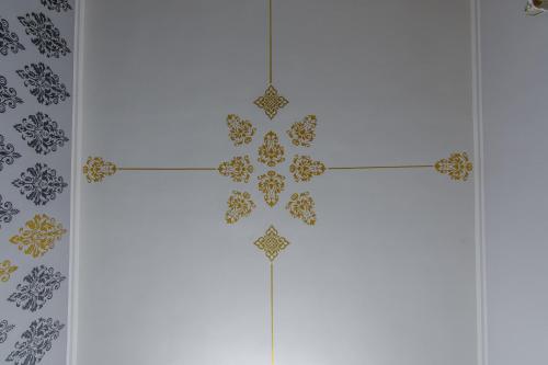 a cross on the wall in a room with tiles at Piazza del Mercato in LʼAquila