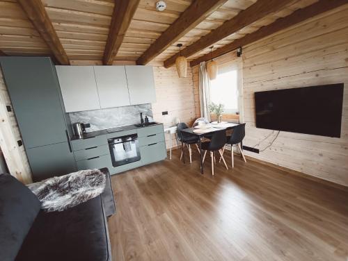 Chill House في Miežonys: مطبخ وغرفة طعام مع طاولة وتلفزيون