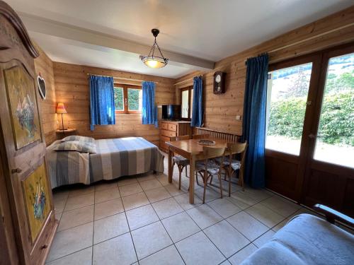 une chambre avec un lit et une table dans une pièce dans l'établissement Petit Lutin 1 - Studio dans chalet sur les pistes, à La Clusaz