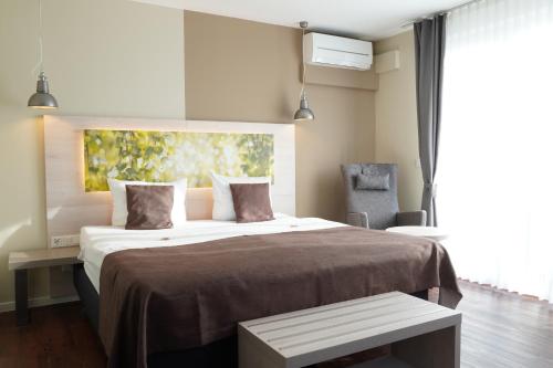 莫尔巴赫Best Western Hotel St. Michael的带一张大床和一把椅子的卧室