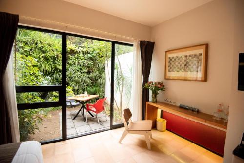 a living room with a sliding glass door with a table and chairs at Nardazul "Casa de Sueños" in Oaxaca City