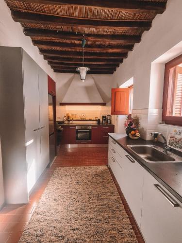 a kitchen with white cabinets and a wooden ceiling at Villa Antigoni Serifos in Serifos Chora