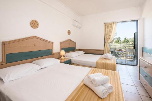 a bedroom with two beds and a balcony at Galaxy Hotel in Porto Heli