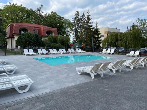 a group of lounge chairs and a swimming pool at Ośrodek Promenada- Horyzont in Jastrzębia Góra