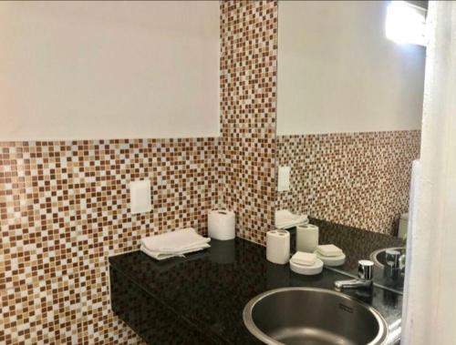 ein Bad mit einem Waschbecken und einem Spiegel in der Unterkunft FlatStudio01 em condomínio residencial na Nova Betânia in Mossoró