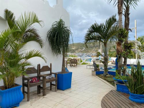a patio with palm trees and benches in a resort at Capitão N Areia Pousada in Arraial do Cabo