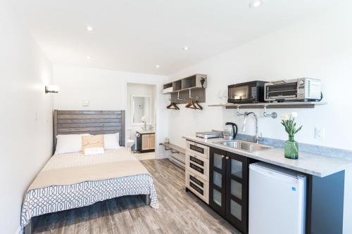 a small kitchen with a bed in a room at Whale House Guest House in Mobile