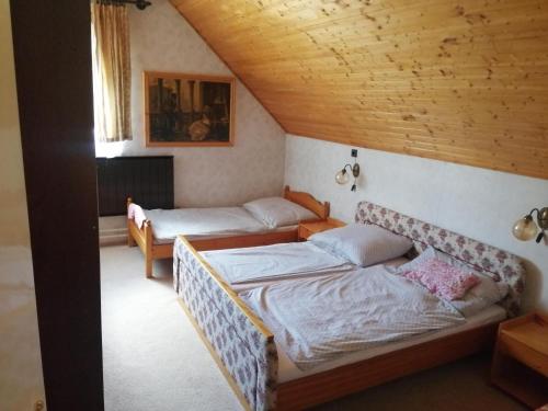 a bedroom with two beds and a wooden ceiling at Pálinkás jó reggelt! in Hévíz