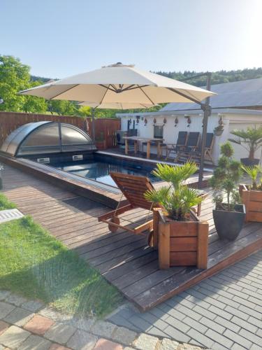 una terrazza in legno con ombrellone e piscina di Luxusferienwohnung-Mager a Freyung